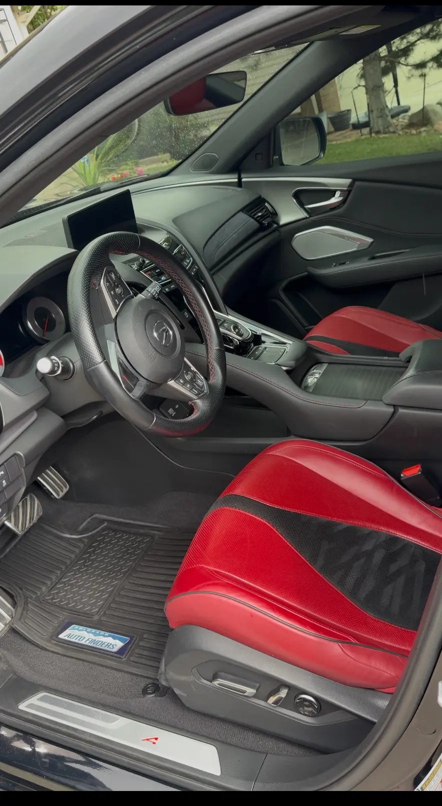 Detailed sports sedan interior with red and black leather seats and spotless floor mats